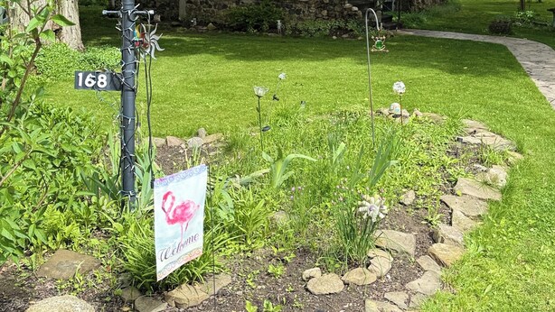 Une petite maison en pierre avec une pancarte indiquant « Rocky Cottage ».