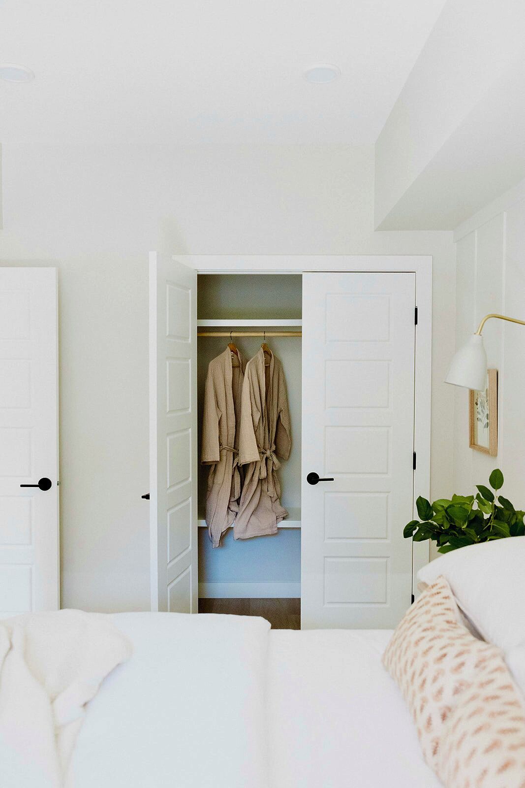 A view of the large guest closet with custom shelving and cozy muslin robes