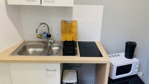 A compact kitchenette with a sink, a microwave, a toaster, and a coffee maker. - T1 bis for 3 people Private and separate kitchen bathroom (Saint-Brieuc)