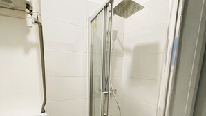 A small, enclosed shower stall with a glass door, a toilet, and a towel rack. - T1 bis for 3 people Private and separate kitchen bathroom (Saint-Brieuc)