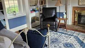 A bedroom with a bed, a bookshelf, a chair, and a fireplace. - The Serene Farm Life...without all the work!  Lots of space and privacy! (Buchanan)
