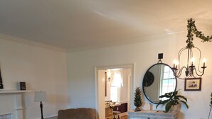 A living room with a checkered floor, a sofa, a chair, a coffee table, a fireplace, a mirror, and a chandelier. - The Serene Farm Life...without all the work!  Lots of space and privacy! (Buchanan)