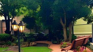 A well-maintained garden with a curved pathway, a bench, and a street lamp. - Siga Gramado-Casa de Vó c TVsmart e Wifi (Gramado)