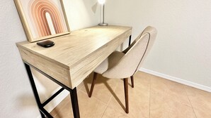 A wooden desk with a chair, a framed picture, and a desk lamp. - Charming 1-bedroom, 20 mins to Airport, Beaches, Gaslamp (Spring Valley)