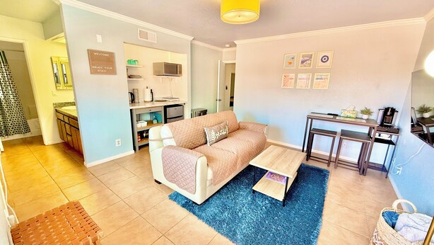 A living room with a sofa, coffee table, and a small dining area with a table and chairs. - Charming 1-bedroom, 20 mins to Airport, Beaches, Gaslamp (Spring Valley)
