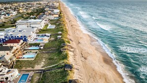 A coastal residential area with beachfront properties, including houses with swimming pools and a beach access path. - Sleeps 28 Beachfront w/ Pool, Hot Tub, Game Room Atlantic Watch by Avantstay (Kill Devil Hills)