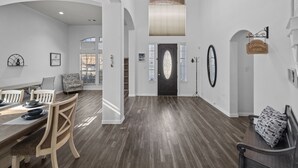 A spacious interior with a dining area, a staircase, and a reception desk. - Keller’s Crown - Huge House Near Stadiums - Hot Tub & Pool Table (Keller)