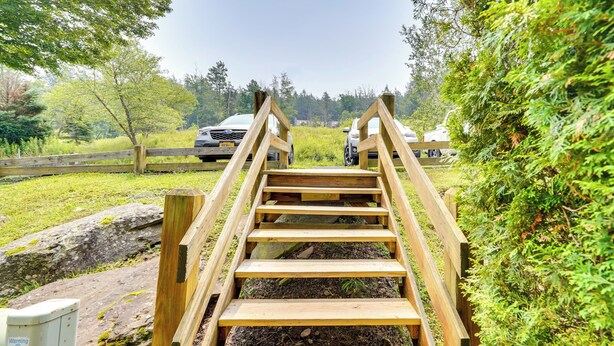 Una escalera de madera que lleva a un área de estacionamiento con vehículos.