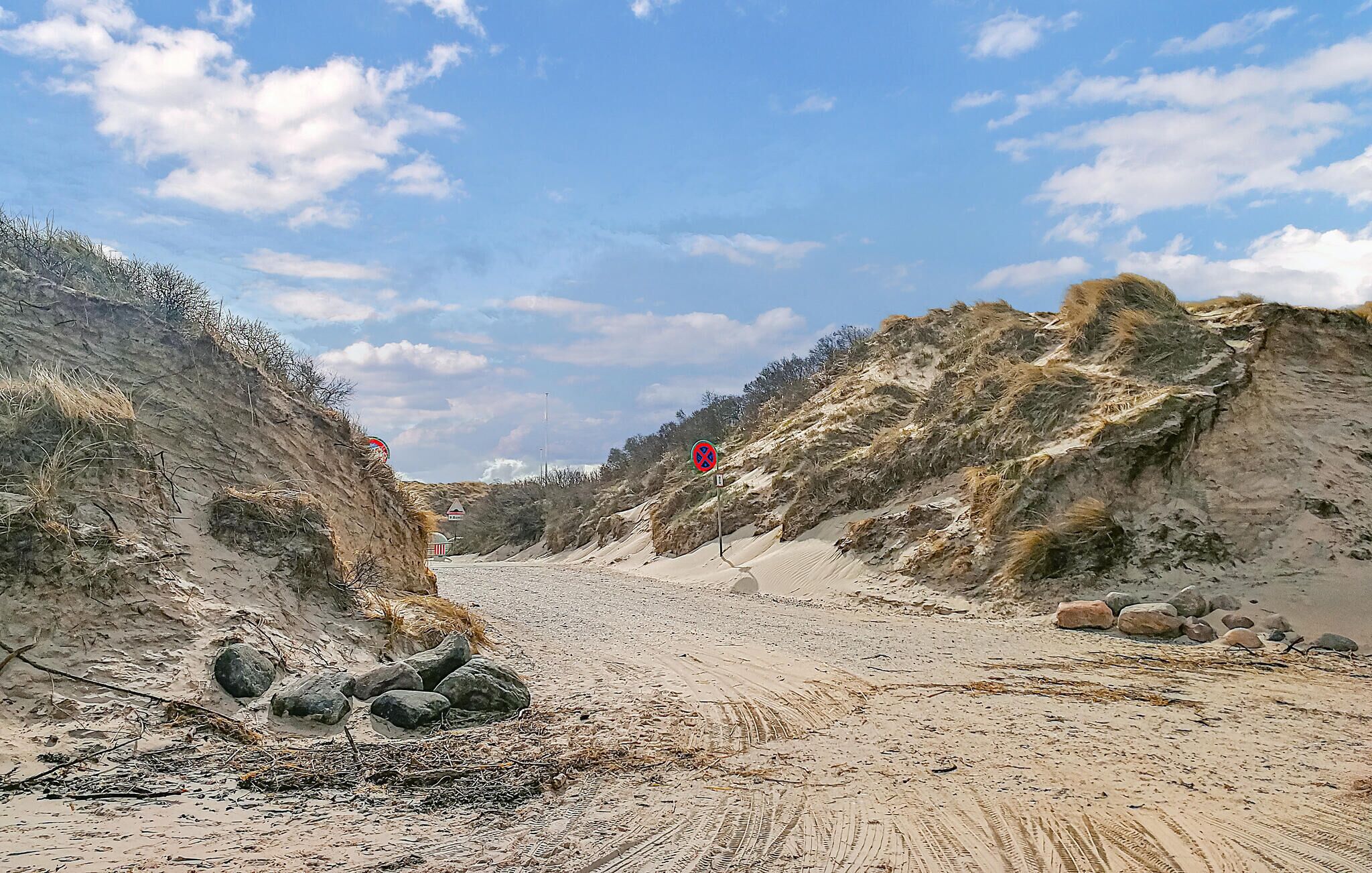 A sandy beach with dunes and a clear sky.