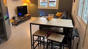 Un espace de vie compact comprenant une cuisine, un coin repas et un canapé.