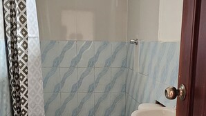 Ein Badezimmer mit Toilette, Waschbecken und Duschbereich.