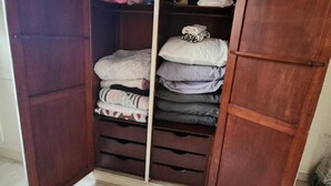 A wardrobe with multiple compartments, some containing folded clothes and others with hanging items. - 3 bedrooms with garage - Read the description  (Centro Juiz de Fora)