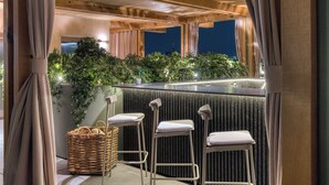 A bar area with three stools, a wicker basket, and a view of the city at night. - ONTO Alvaro Obregon Mexico City (Mexico City)