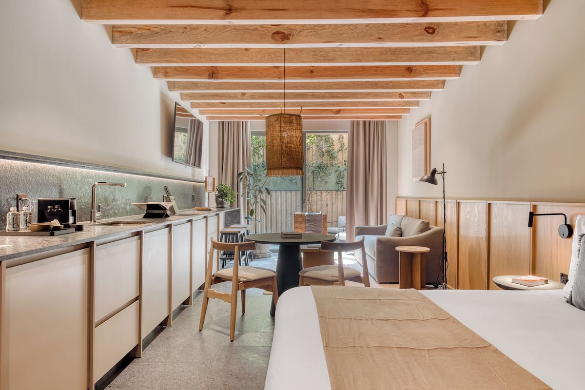 Habitación de hotel moderna con cocina, una mesa de comedor y una zona de estar acogedora.