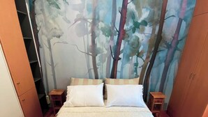 A bedroom with a large bed, two nightstands, a wardrobe, and a forest-themed wall mural. - Downtown Oasis (Kerkira)