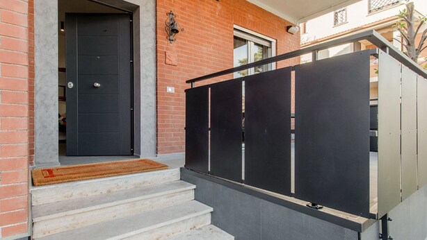 A black door, a staircase, and a black metal gate. - Villa Scini by Rentbeat (Roma)