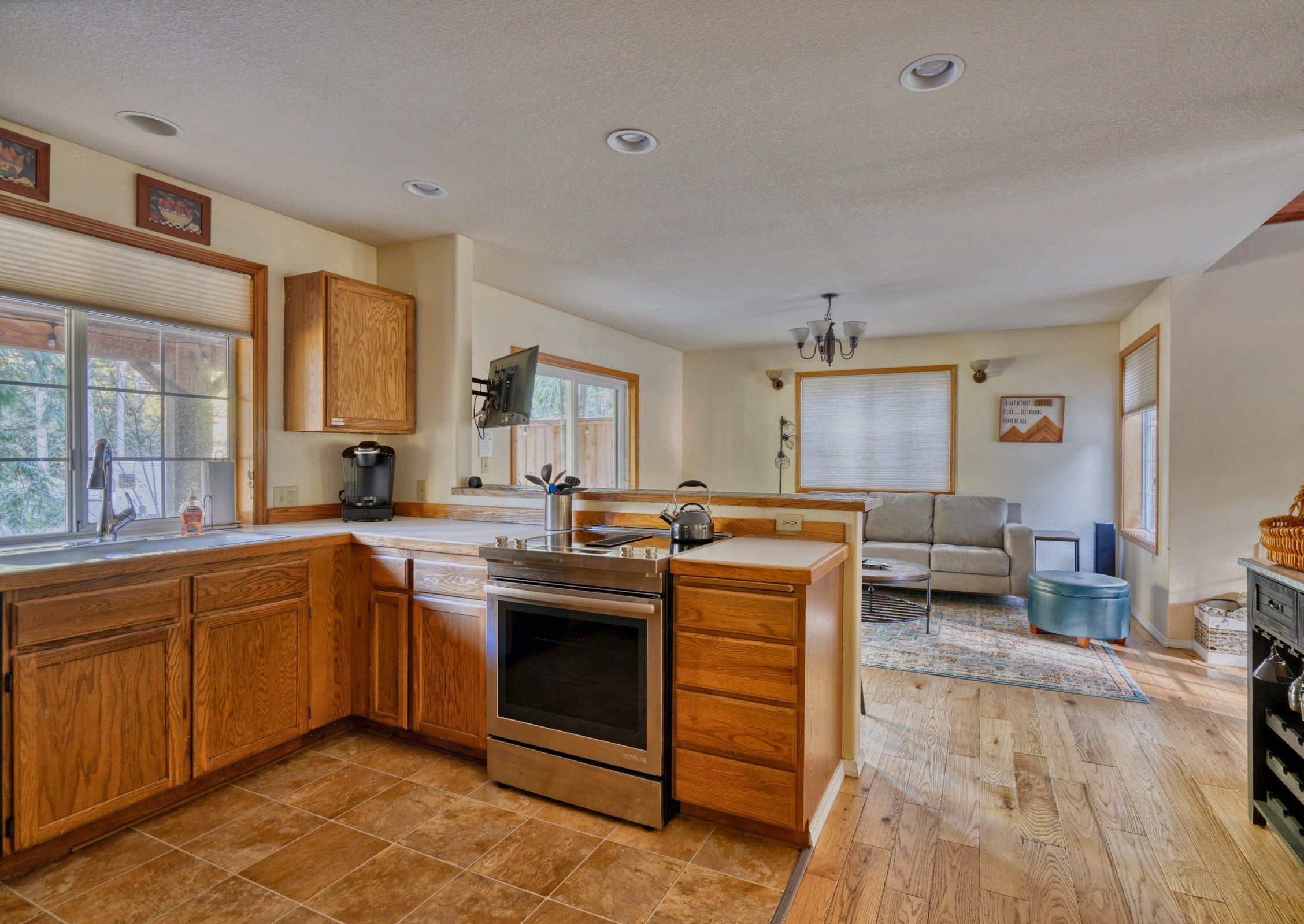 A modern kitchen with wooden cabinets, a built-in oven, and a coffee maker.