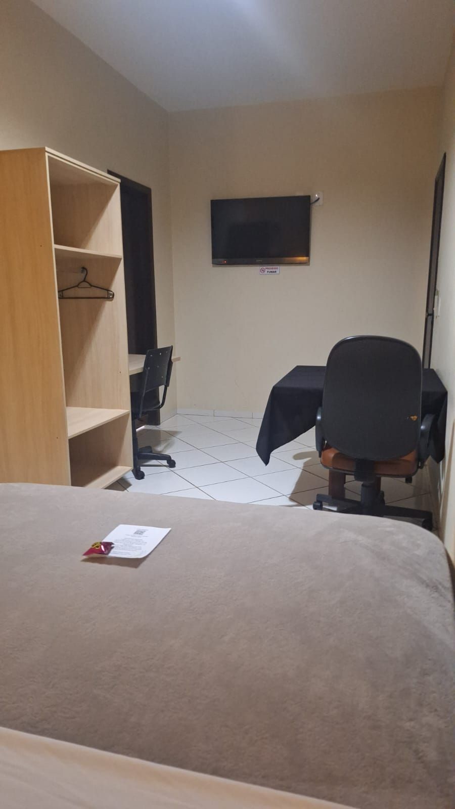 Une chambre d’hôtel équipée d’un lit, d’un bureau, d’une chaise, d’une télévision et d’une armoire.