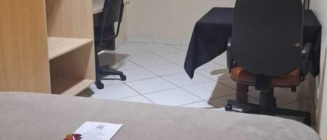 Une chambre d’hôtel équipée d’un lit, d’un bureau, d’une chaise, d’une télévision et d’une armoire.