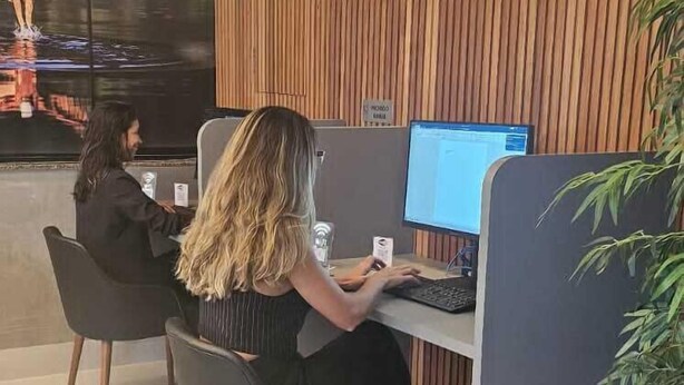 Un espace de bureau moderne avec des cloisons, une grande fenêtre et un mur recouvert de panneaux en bois.