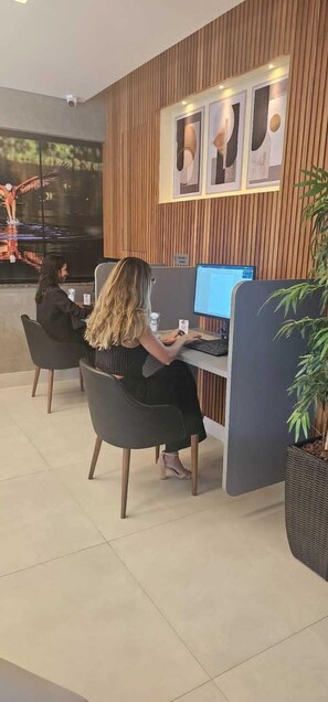 Un espacio de oficina moderno con cubículos, un ventanal grande y un revestimiento de pared de madera.