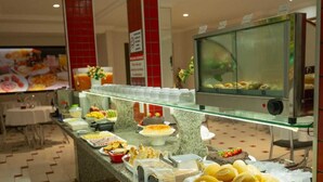 Un espace buffet proposant une variété de plats et un point de service pour les boissons, où les clients peuvent se servir eux-mêmes.