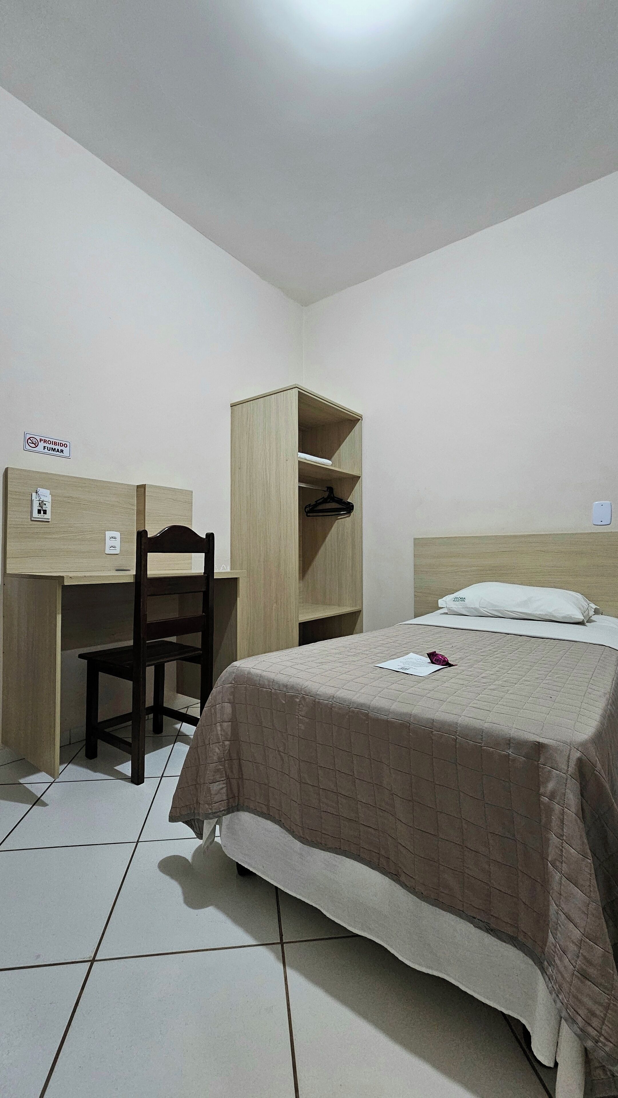 Un dormitorio con cama, escritorio de madera y armario.