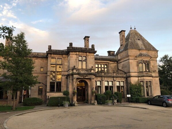A historic building with a prominent entrance, large windows, and a tower.