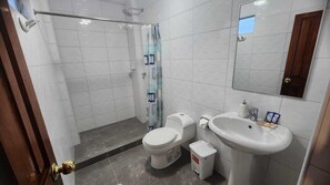 Un baño con ducha, inodoro y lavamanos.