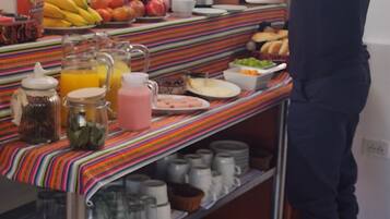 A buffet setup with various food items and beverages on a striped tablecloth.