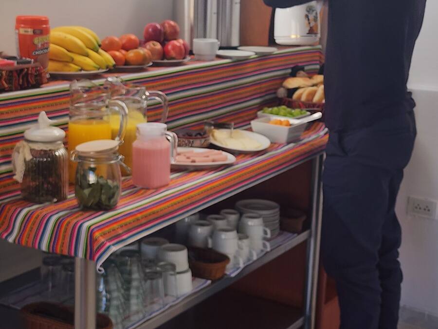 A buffet setup with various food items and beverages on a striped tablecloth.
