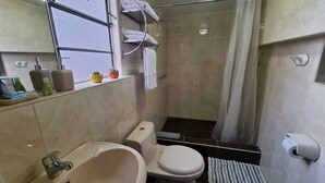 A bathroom with a bathtub, toilet, and shower. There are towels and toiletries on the counter. - INCA PALACE EXPERIENCE (Puno)