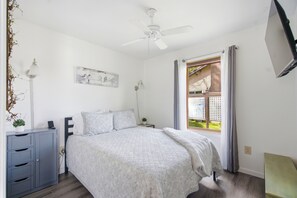 A bedroom with a bed, bedside tables, a ceiling fan, a window with curtains, and a wall-mounted artwork. - 5 min to Colgate, Pet Friendly, Sleeps 6 (Madison)