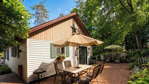 Une maison en bois avec un patio, du mobilier d’extérieur et une étoile sur le toit.