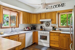 A kitchen with wooden cabinets, a stove, a dishwasher, and a coffee maker. - 5 min to Colgate, Pet Friendly, Sleeps 6 (Madison)