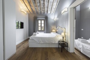 Une chambre à coucher moderne avec un lit, une table de chevet et une fenêtre avec des rideaux.