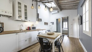 A kitchen with white cabinets, a wooden countertop, a dining table with black chairs, and hanging light fixtures. - <h3>Central Nest</h3>Located in Via Guelfa, in the heart of the historic center of Florence, this delightful apartment offers a comfortable and modern refuge just steps away from the Central Market and the Santa Maria Novella Station.On the third and top (Firenze)