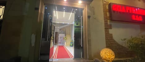 L'entrée d'un hôtel, avec un tapis rouge menant à un escalier.