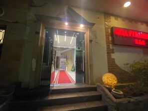 L'entrée d'un hôtel, avec un tapis rouge menant à un escalier.