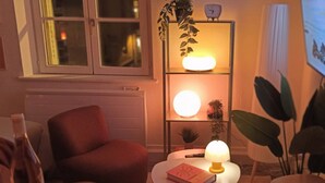 A cozy living room with a red armchair, a small round table with a book and a lamp, and a shelf with plants and a clock. - Sunset Lovers - WiFi - Netflix - Cosy atmosphere (Nancy)