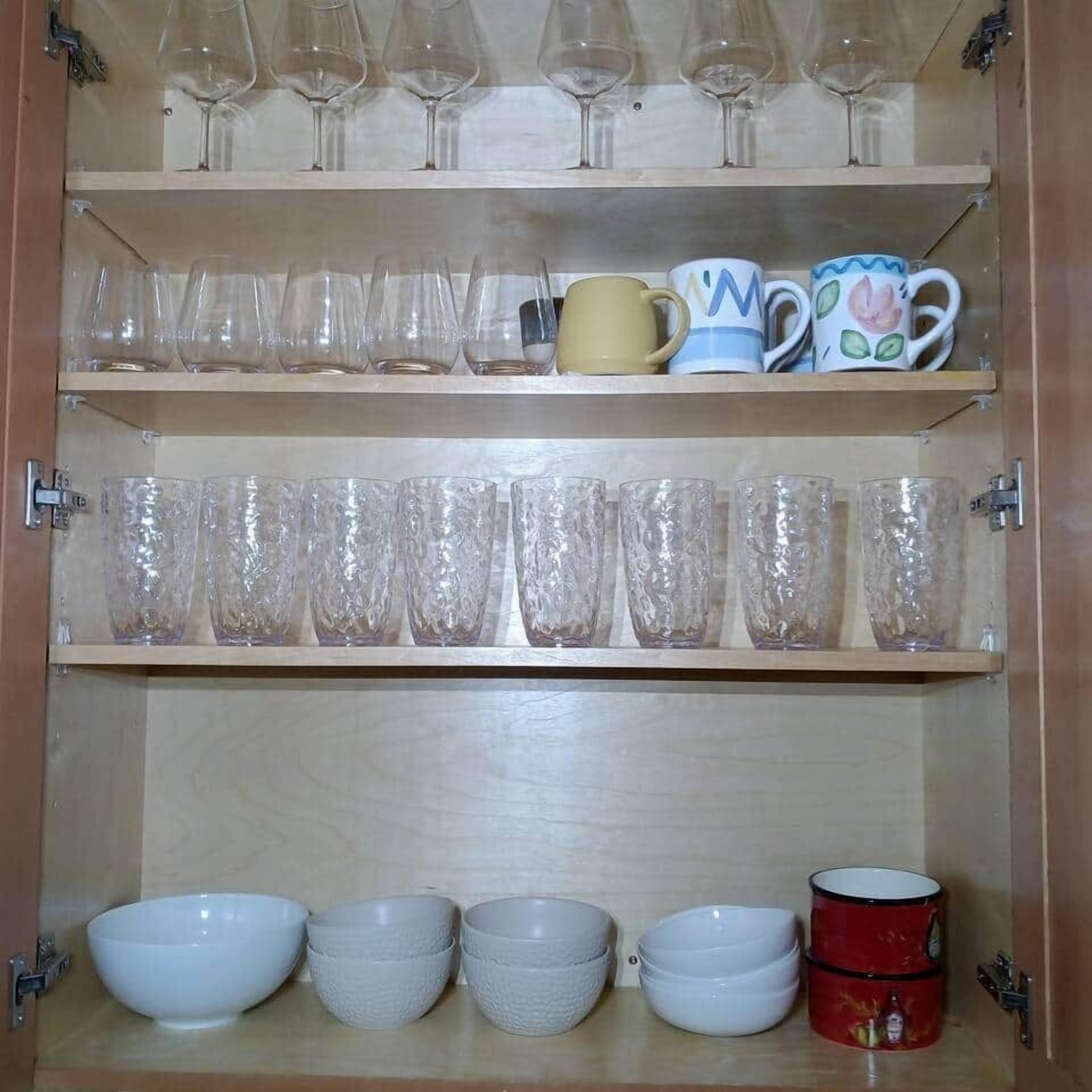 Un meuble avec des étagères pour ranger des verres à vin, des tasses et des bols.