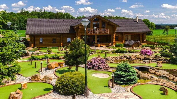 A wooden lodge with a porch and a golf course in front. - Holiday Home in Kladno With Private Pool (Lany)