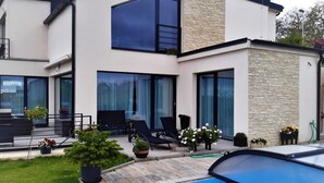 A modern two-story house with a swimming pool, large windows, and outdoor seating. - Holiday Home in Kladno With Private Pool (Lany)