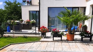 A modern house with a swimming pool, outdoor furniture, and potted plants. - Holiday Home in Kladno With Private Pool (Lany)