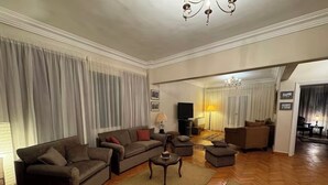 Una sala de estar amplia con un conjunto de sofá, una mesa de centro y una televisión.
