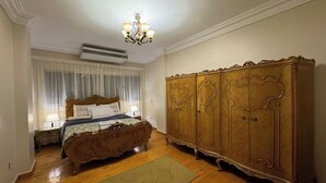 Un dormitorio con una cama de madera, un armario grande y una araña.