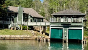 A lakeside cabin with a dock, a covered boat house, and a staircase leading to the main building. - Green Acres – Your lakefront place to be! (Lakemont)