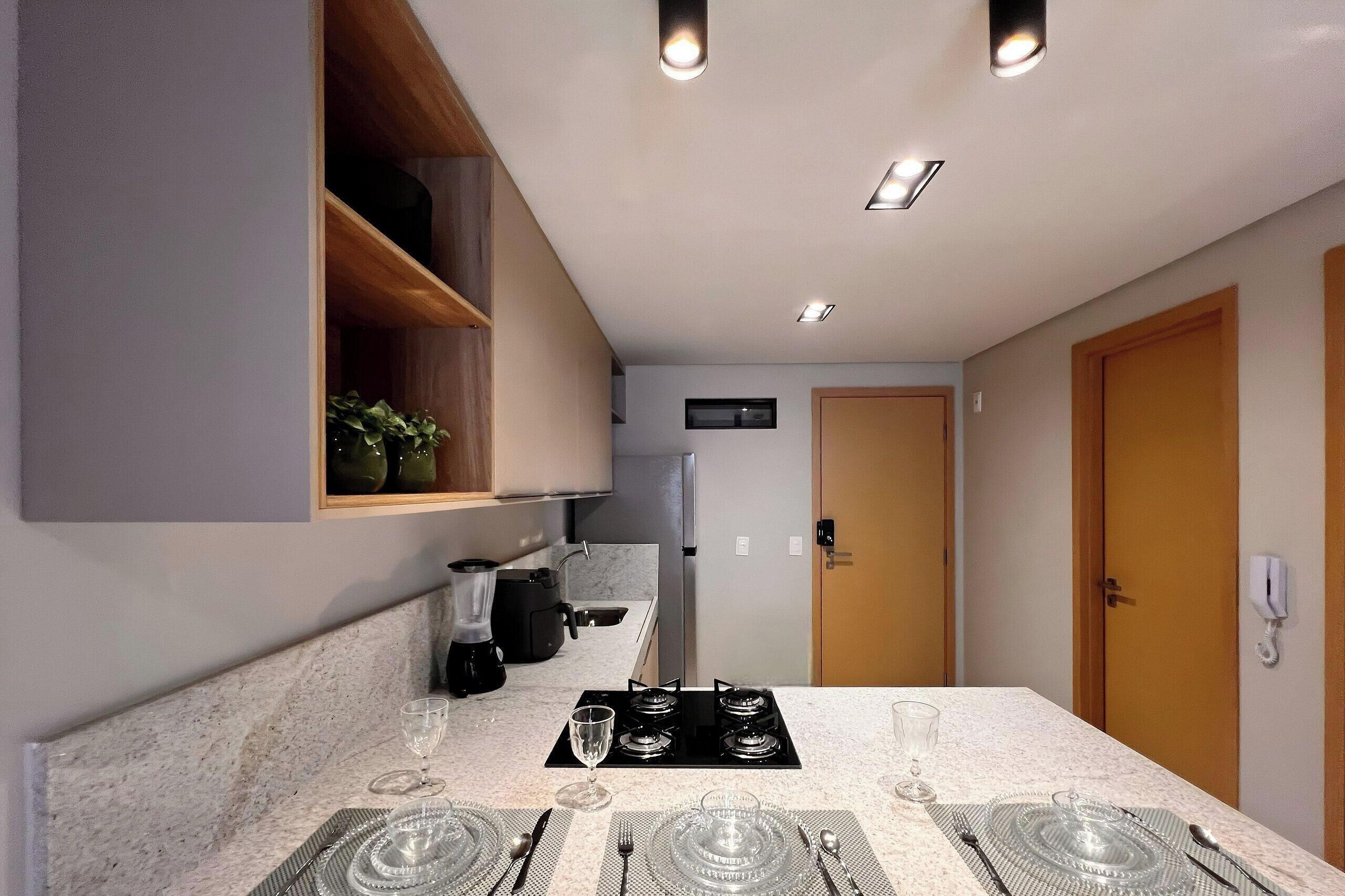 Una cocina moderna con estufa integrada, cafetera y refrigerador.