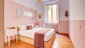 Une chambre à coucher avec un lit, une table de chevet, une commode et une fenêtre.