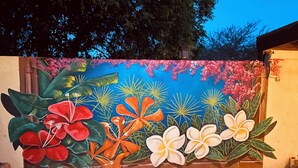 A wall mural with tropical flowers and a hexagonal tile floor. - Sol appartments with pool (Willemstad)